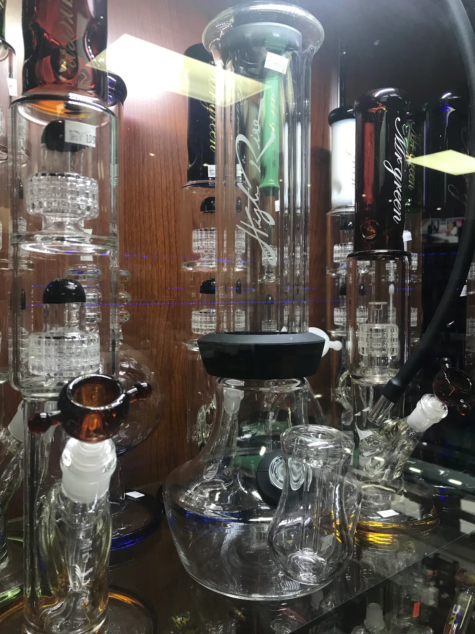 Tall glass water pipes with percolators standing on a shelf
